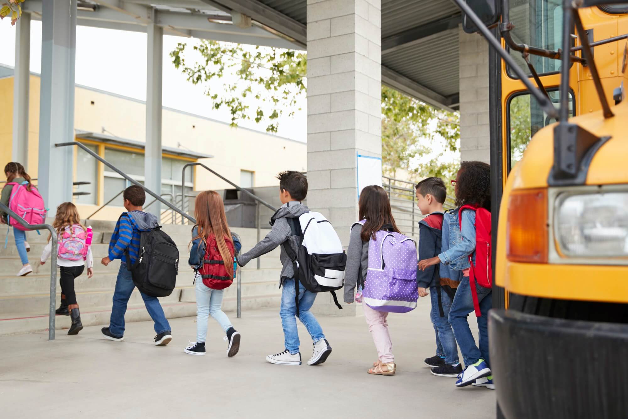 Elementary school kids arrive at school from the school bus